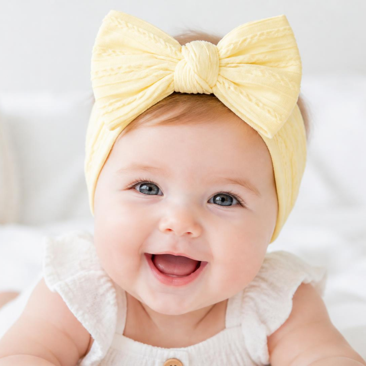 Beaming baby in a lemon soft bow headband