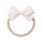Dotty Embroidered Cotton Baby Bow in Rouge — baby accessory styled flat lay with nursery accessories