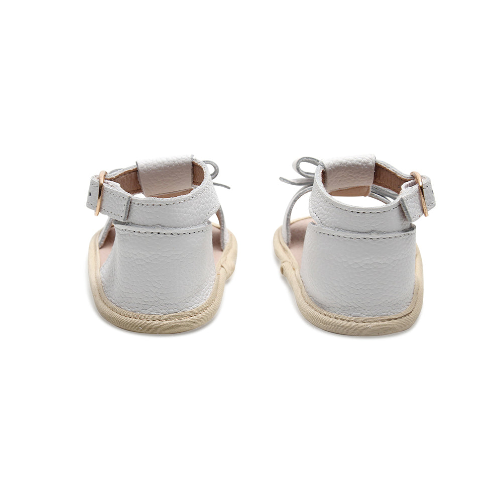 Baby feet in baby sandals on soft surface — Coconut White Leather Baby Bow Sandal