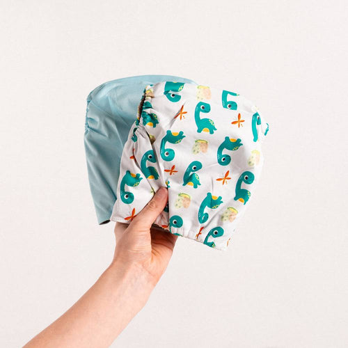 "Georgie Porgie" Dino Nappy Trio — Unisex Baby Gift Bundle — dinosaur baby gift set showing face and soft texture