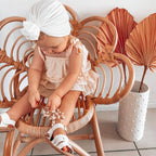 Snow White Weave Leather Baby Sandal — baby sandals styled flat lay with nursery accessories