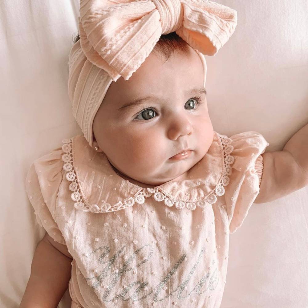 Bowie Double Bow Headband in Fairy Floss Pink — baby headband styled flat lay with nursery accessories