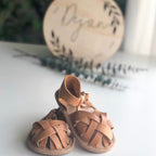 Nutmeg Wax Leather Baby Sandal — baby sandals styled flat lay with nursery accessories