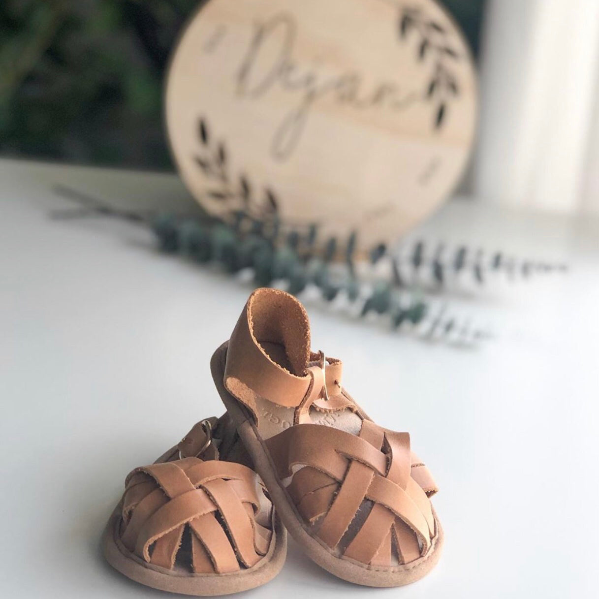 Nutmeg Wax Leather Baby Sandal — baby sandals styled flat lay with nursery accessories