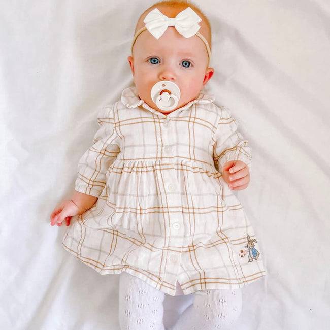 Tinka Tiny Baby Bow in White — close-up of bow on white baby hat