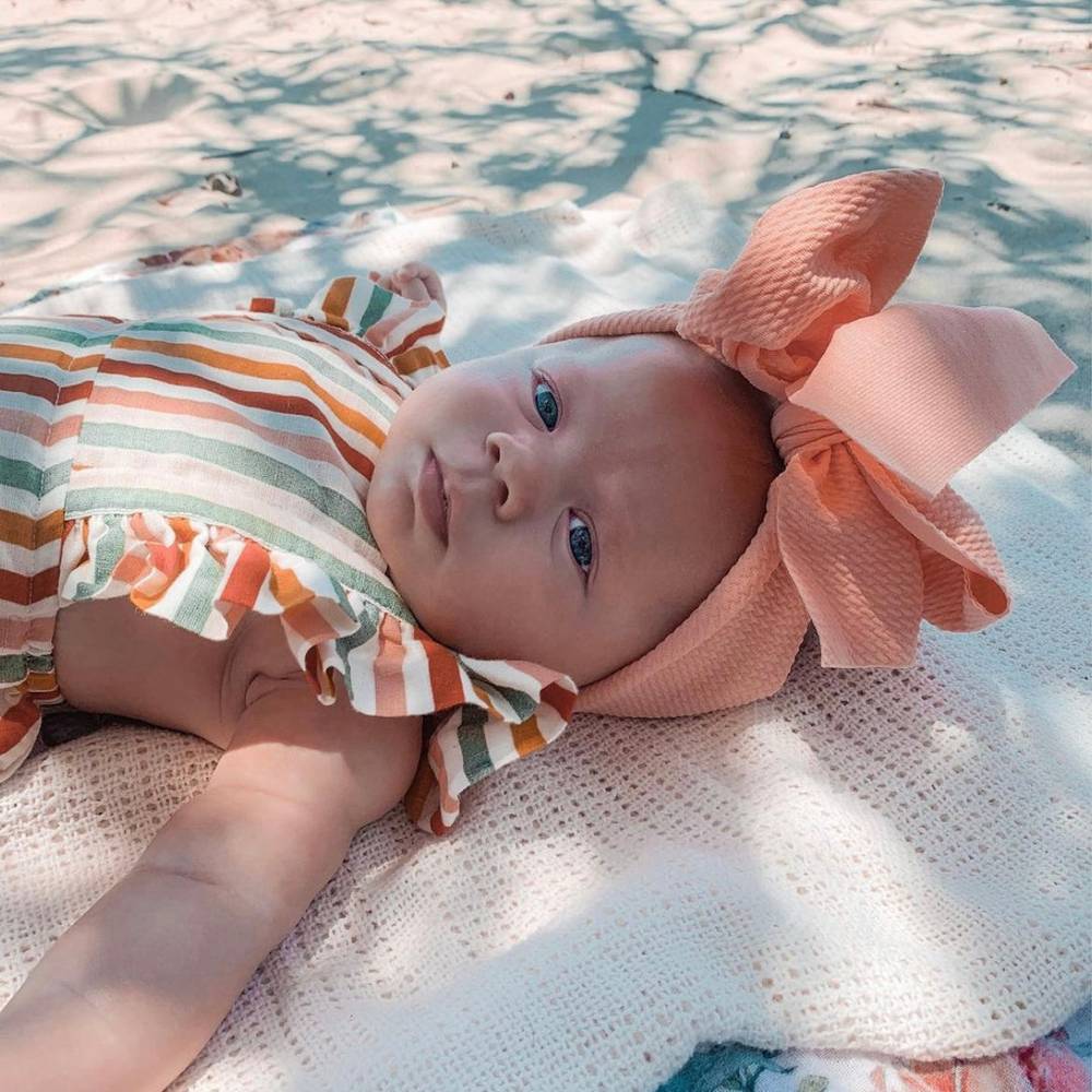 Baby Adjustable Bow Headband in Flamingo — cat baby headband showing face and soft texture