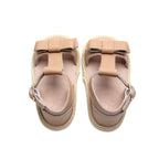 Pale Pecan Leather Baby Bow Sandal — baby sandals styled flat lay with nursery accessories