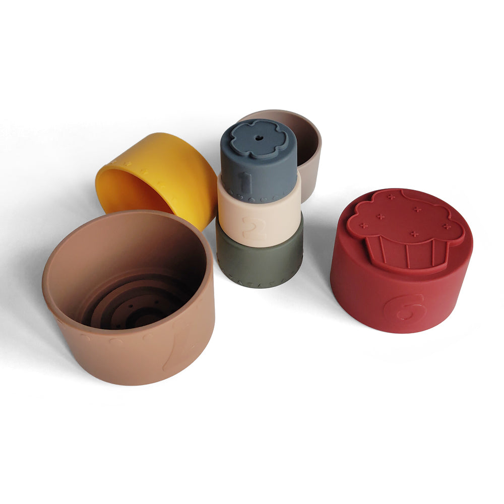 Silicone Baby Stacking Cups Bath & Beach in Earthy — baby hat styled flat lay with nursery accessories