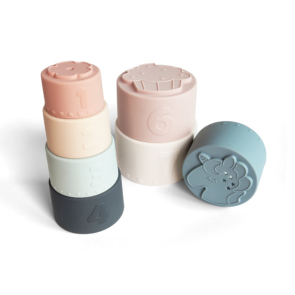 Silicone Baby Stacking Cups Bath & Beach in Pastel — baby hat styled flat lay with nursery accessories