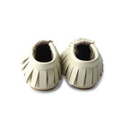 Oatmeal Cookie Baby Fringed Moccasin Shoe — baby shoes styled flat lay with nursery accessories