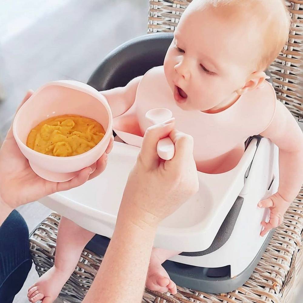 Silicone Baby Feeding Set in Cherry Blossom — baby bib styled flat lay with nursery accessories