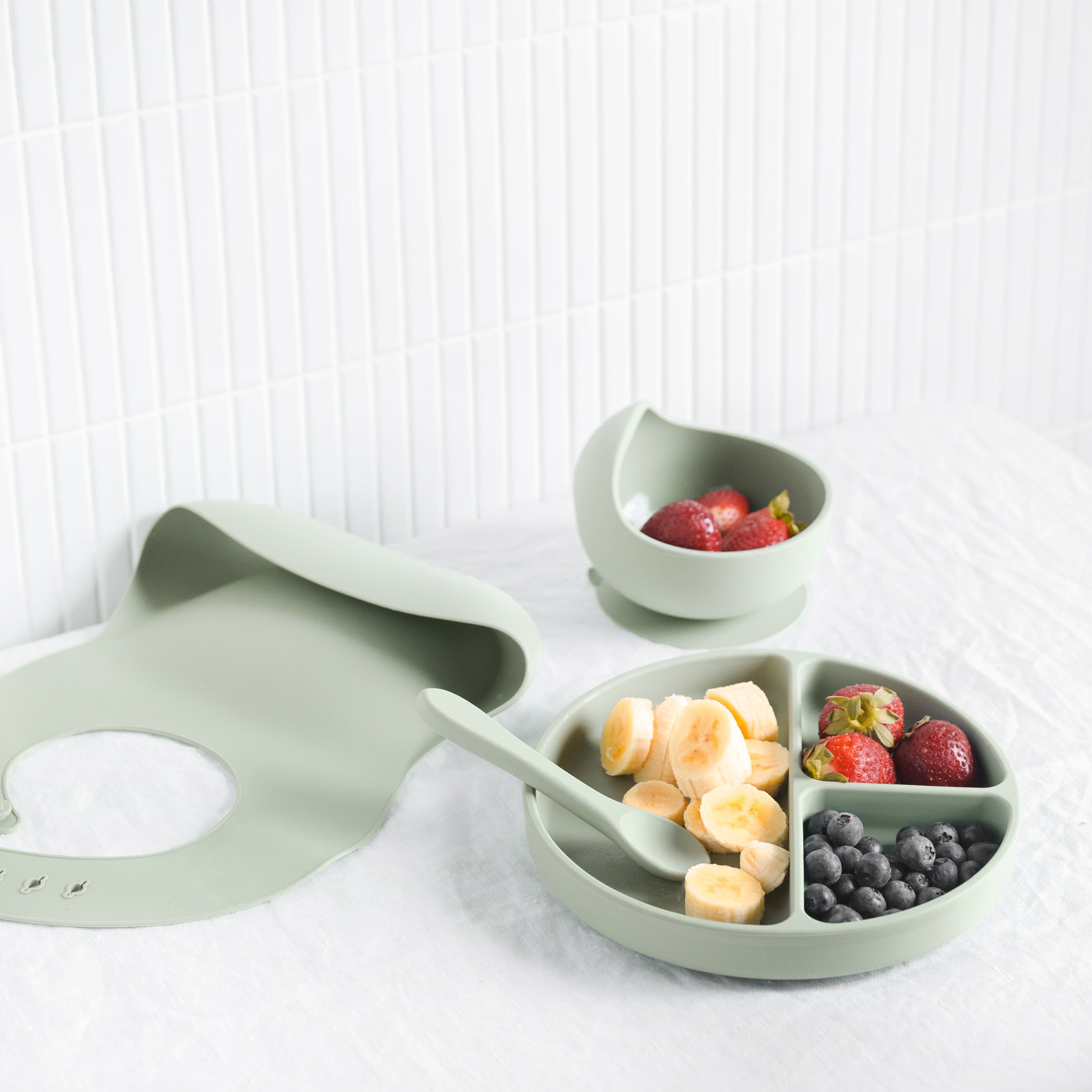 Silicone Baby Feeding Set in Koala Grey — baby bib styled flat lay with nursery accessories