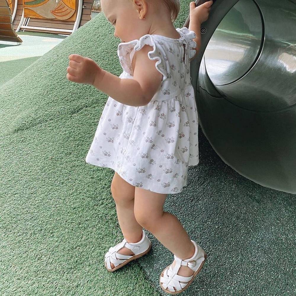 White Leather Baby Sandal — baby sandals styled flat lay with nursery accessories