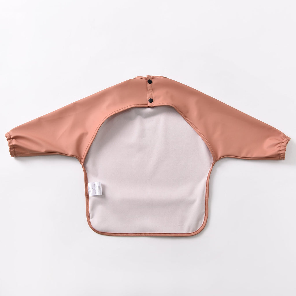 Green Smoke Waterproof Baby Smock Bib Long Sleeve — baby bib styled flat lay with nursery accessories