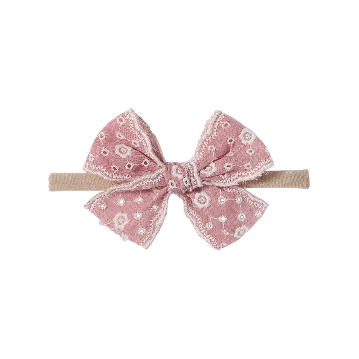 Lacey eyelet baby bow headband in flamingo dusty pink, broderie anglaise bow with cream embroidered eyelets and scalloped edges on a soft nylon band, Sommerfugl Kids