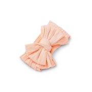 peach orange ribbed knit baby headband with re-tieable oversized double bow, designed for newborns and toddlers