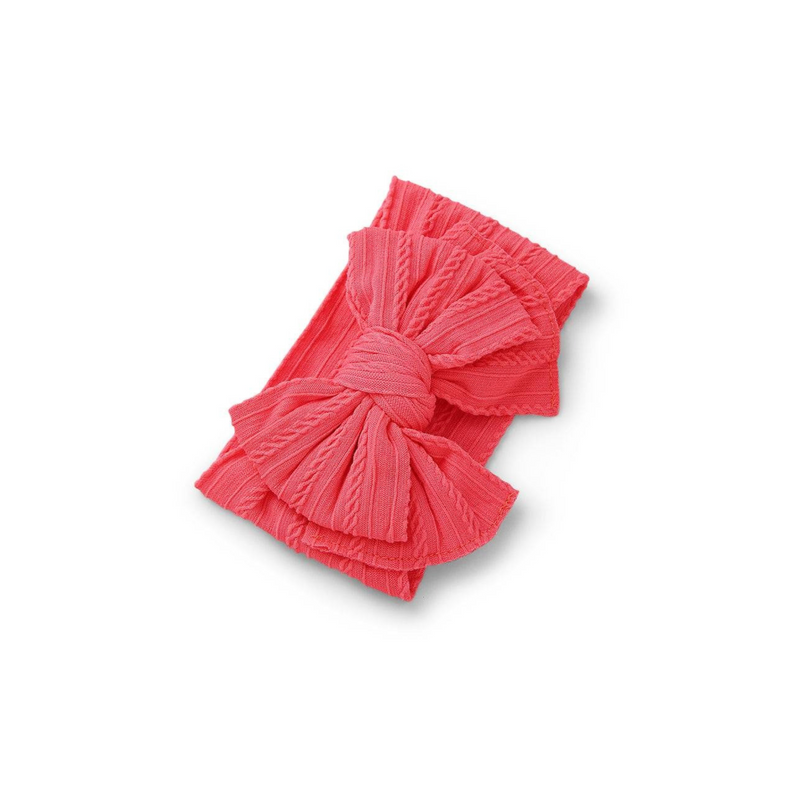 punched pink ribbed knit baby headband with re-tieable oversized double bow, designed for newborns and toddlers