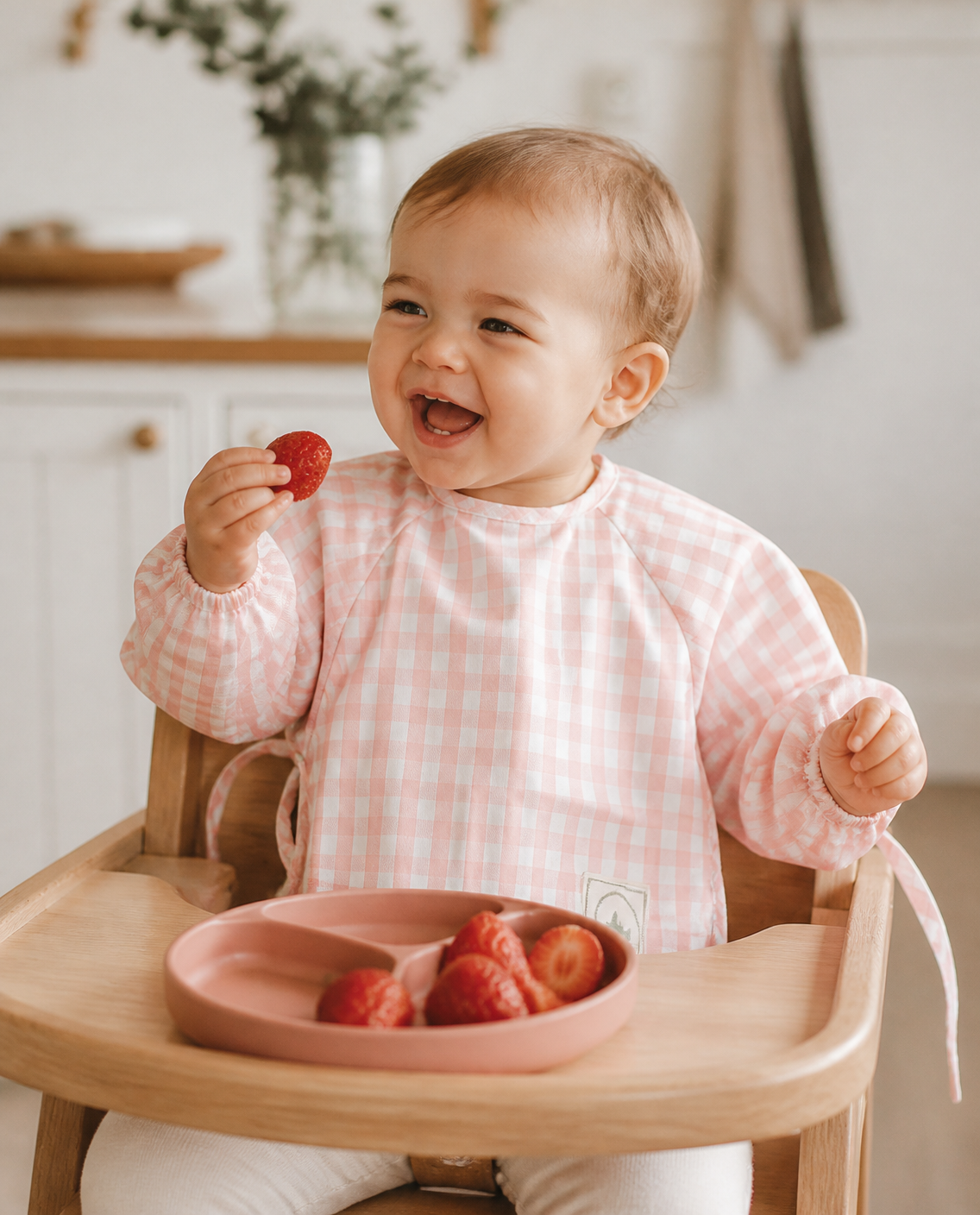 Baby in a pink gingham smock bib
