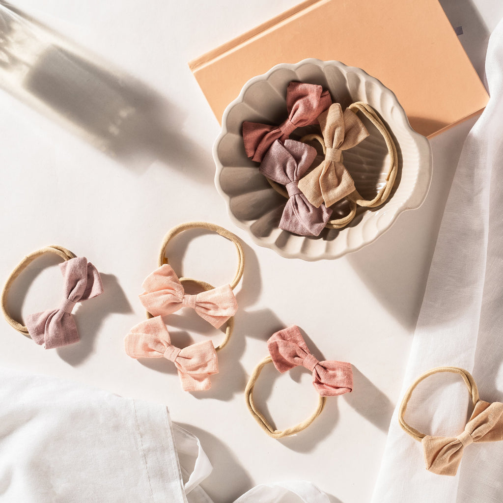 Tinka bow baby headbands in blush, flamingo, peony and apricot linen bows on soft nylon bands